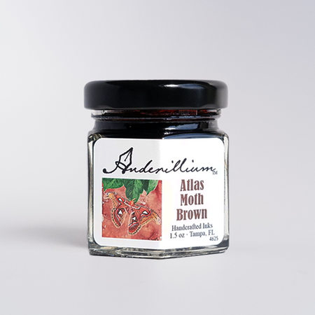 Anderillium Atlas Moth Brown fountain pen ink in a glass bottle with a black cap, showcasing rich brown ink color.