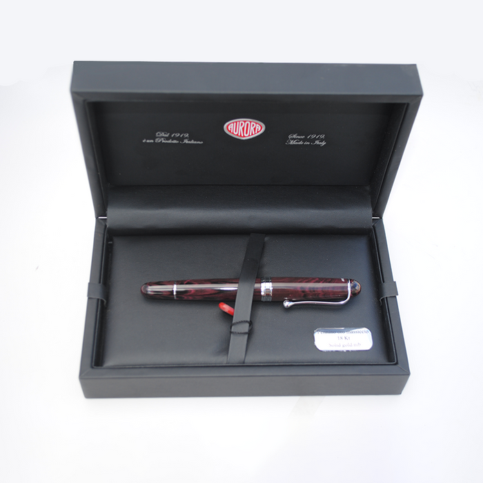 Aurora Ebonite Magenta fountain pen with gold accents, showcasing sleek design and smooth writing tip.