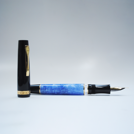 Gioia light blue fountain pen with gold accents, showcasing its elegant design and smooth ink nib.