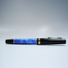 Light blue Gioia fountain pen with gold accents, showcasing a sleek design and fine nib on a white background.