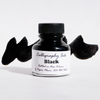 Black calligraphy ink in a glass bottle by Papier Plume, featuring elegant ink for artistic lettering and writing.