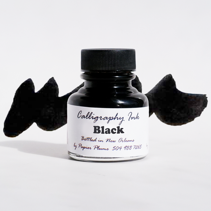 Black calligraphy ink in a glass bottle by Papier Plume, featuring elegant ink for artistic lettering and writing.
