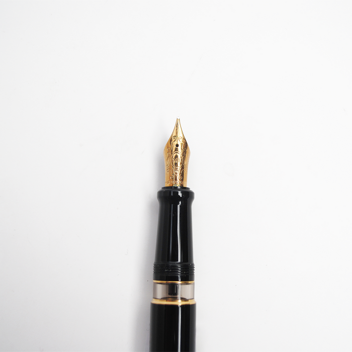 Aurora Optima black fountain pen with gold trim, showcasing a sleek design and elegant nib on a white background.