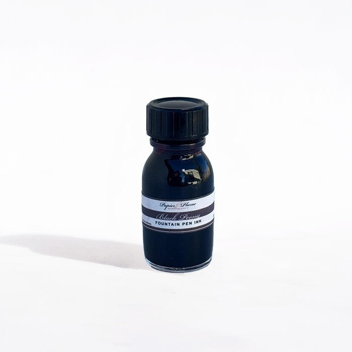 Bottle of Papier Plume fountain pen ink in Black Peony color, with black ink swatch on white background.
