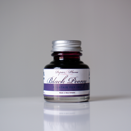 Papier Plume black peony fountain pen ink bottle with black ink visible inside and elegant label.