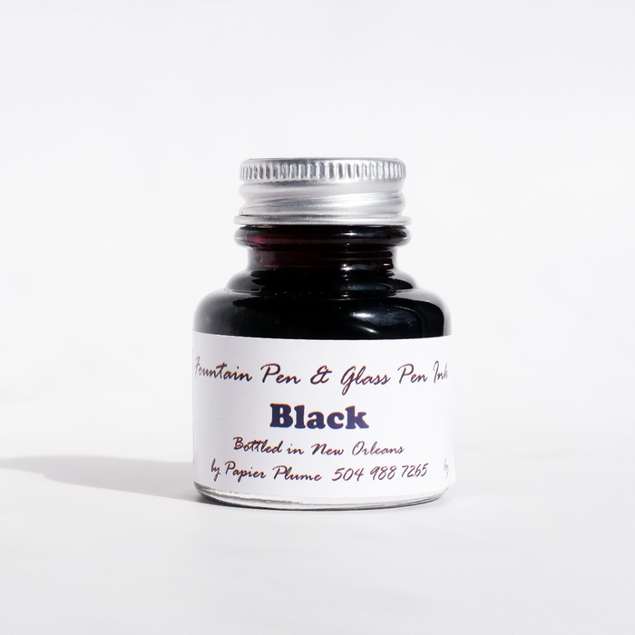 Black fountain pen ink bottle by Papier Plume, showcasing smooth ink for elegant writing and calligraphy.