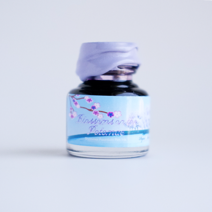 Papier Plume DC Pen Show blossoming fountain pen shimmer ink in a glass bottle with vibrant floral design.