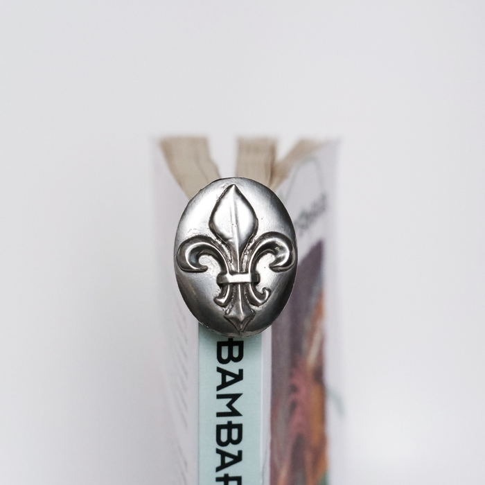 Le Potier D'Etain Fishhook Bookmark featuring a detailed Fleur de Lis design, made of metal for durable page marking.