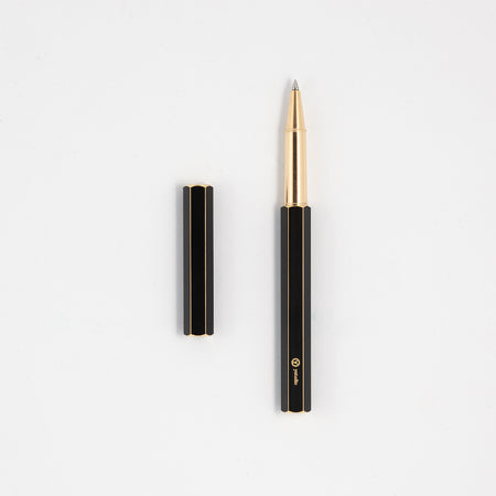 Y Studio Classic Revolve black rollerball pen with sleek design and metallic brassing, shown on a neutral background.