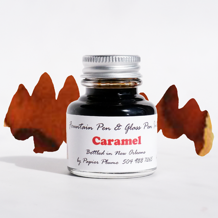 Papier Plume fountain pen ink in caramel color, showing a glass bottle with a black cap and ink label on a white background.