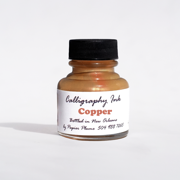 Copper metallic calligraphy ink in a Papier Plume bottled container with a smooth, shiny finish for elegant lettering.