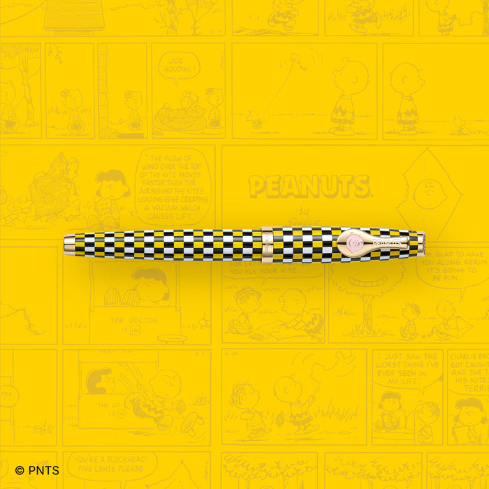 Esterbrook Charlie Brown Estie fountain pen with comic strip background featuring Peanuts characters and Charlie Brown design.