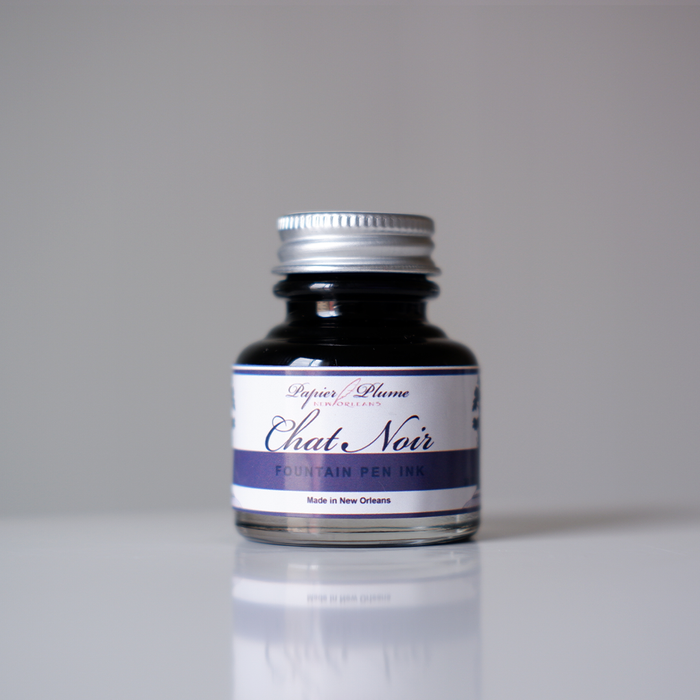 Black fountain pen ink bottle from Papier Plume's Chat Noir collection, featuring elegant ink in a glass container