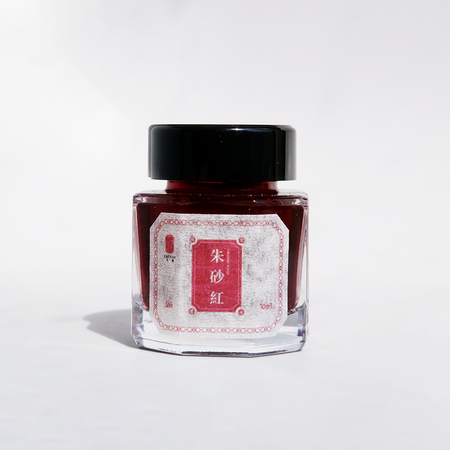 Bottle of Cathay Cinnabar Rouge fountain pen ink with vibrant red ink visible in the glass container.