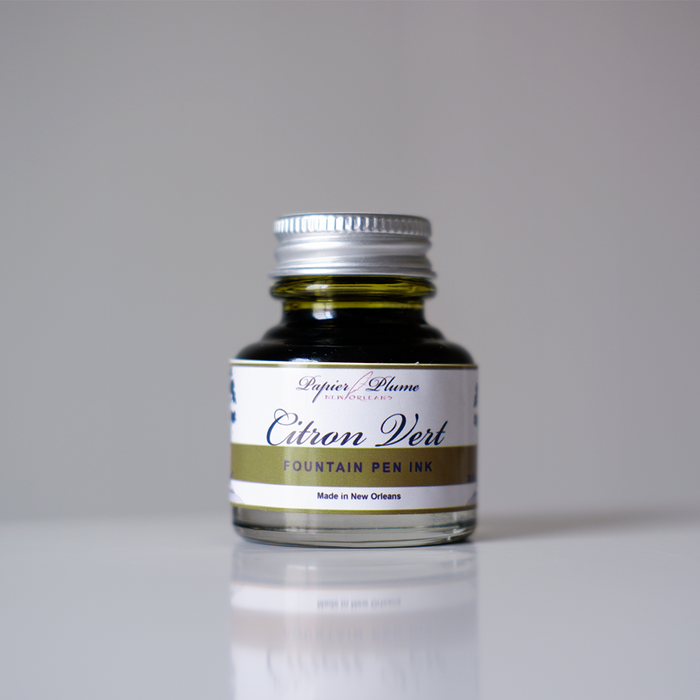 Papier Plume fountain pen ink in vibrant citron vert green, showcasing the bright, smooth ink in a glass bottle.