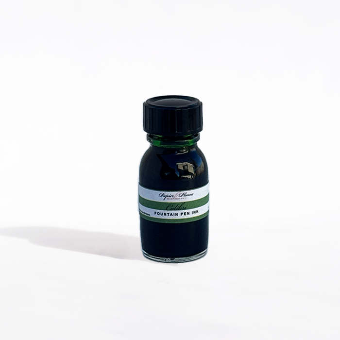 Bottle of Papier Plume Colibri fountain pen ink with vibrant blue ink visible inside the glass bottle.