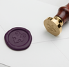 Papier Plume wax seal featuring a crawfish and Fleur de Lis symbol on a natural-colored wax stamp.