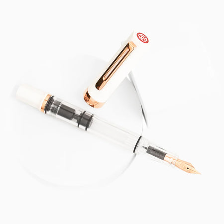 Twsbi Eco fountain pen with white body and rose gold accents, sleek and elegant writing instrument on a neutral background.