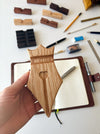 Eng Leather Co. wooden pen rest with sleek design, holding a pen and nib on a polished oak surface.