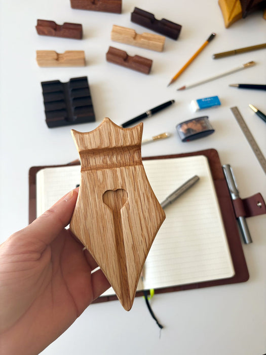 Eng Leather Co. wooden pen rest with sleek design, holding a pen and nib on a polished oak surface.