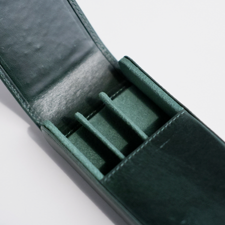 Green leather pen case by Eng Leather Co. with three compartments, designed to securely hold and organize pens.