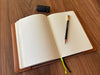 A vegan A5 size journal cover by Eng Leather Co. in smooth camel-colored apple leather with stitched edges.