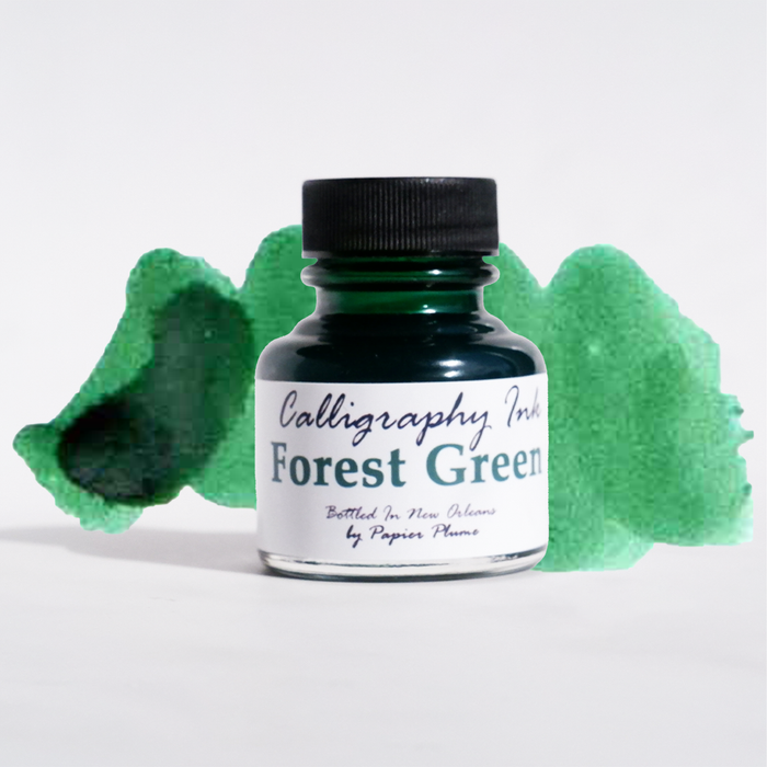 Bottle of Papier Plume Forest Green calligraphy ink with a clear glass container and vibrant green ink inside.