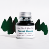 Bottle of Papier Plume forest green fountain pen ink with a clear label, designed for smooth writing and vibrant ink flow.