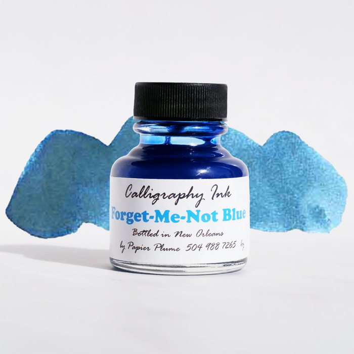 Bottled Papier Plume calligraphy ink in Forget-Me-Not Blue with a glass bottle and ink swatch, ideal for artistic lettering and calligraphy.