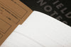 Field Notes ruled paper memo book with orange cover and elastic band, compact and portable writing pad for notes and ideas.