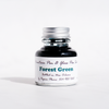 Papier Plume forest green fountain pen ink in a glass bottle, vibrant green ink visible through the transparent container.