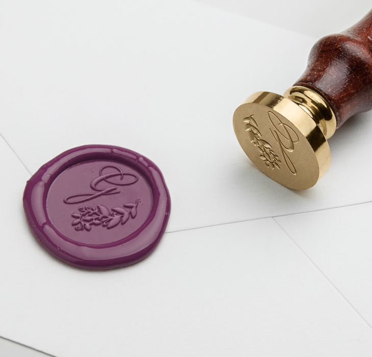 Papier Plume wax seal featuring a elegant script monogram design on a white background.