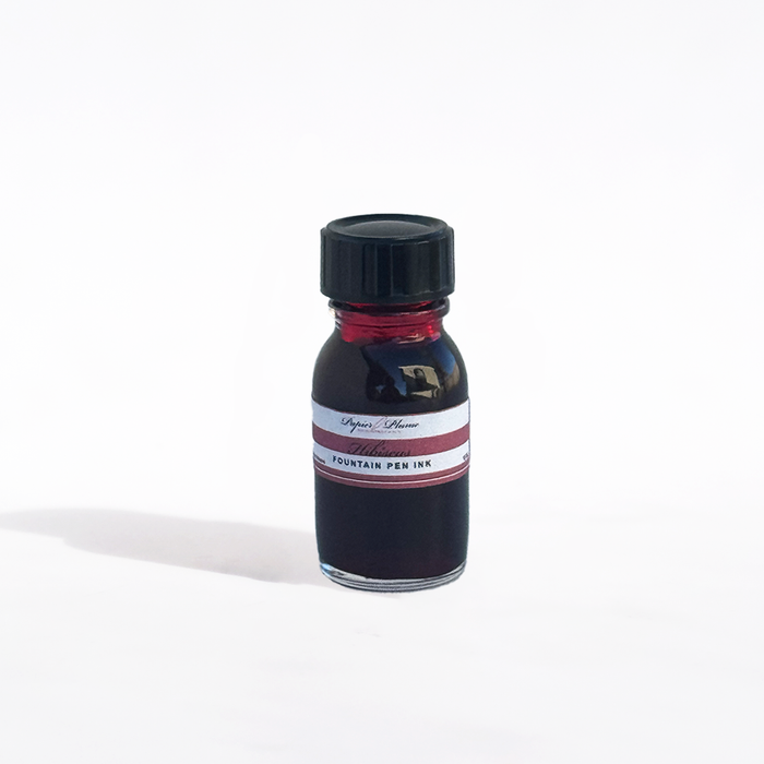 Papier Plume fountain pen ink in Hibiscus color, vibrant pinkish-red ink bottle with ink swatch and label.