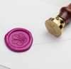 Papier Plume wax seal with hibiscus flower symbol in vibrant red and gold, showcasing intricate floral design on a wax seal.