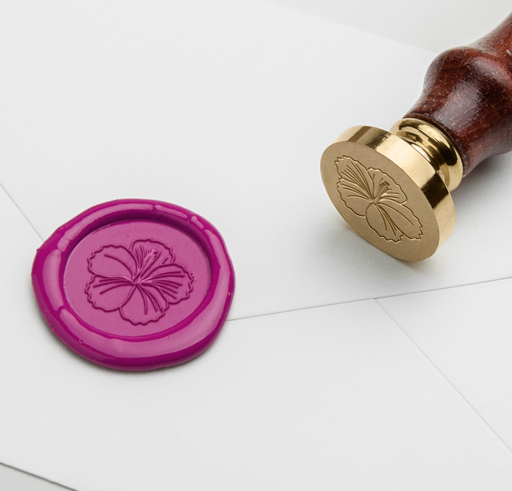 Papier Plume wax seal with hibiscus flower symbol in vibrant red and gold, showcasing intricate floral design on a wax seal.