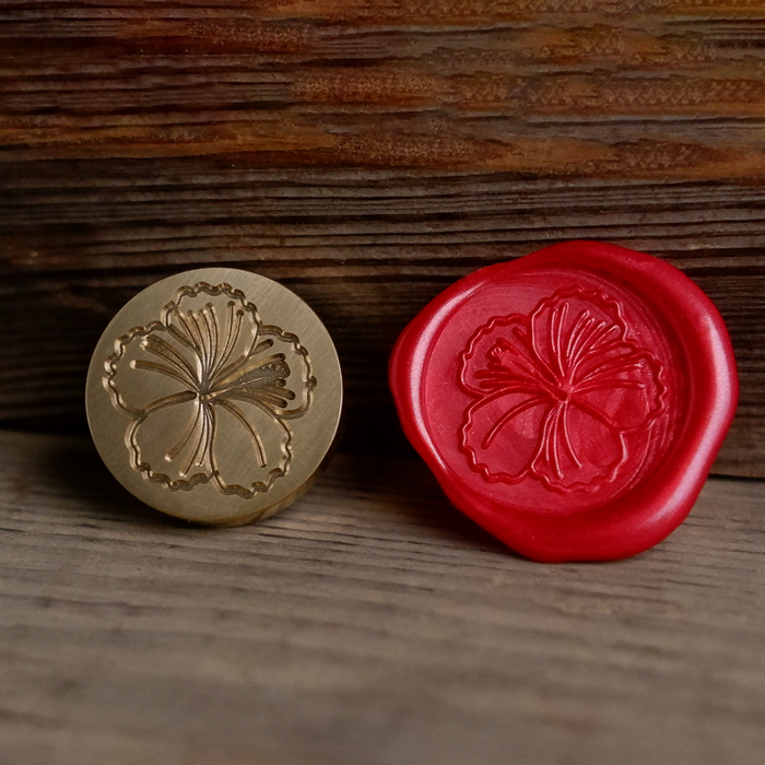 Pink hibiscus flower wax seal with Papier Plume Wax Seal Set, featuring a decorative floral design on a white background.