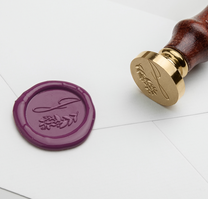 Papier Plume wax seal featuring a J-script monogram on a natural wax surface, ideal for elegant correspondence and embellishments.