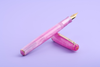 Esterbrook Love Potion Jr fountain pen with pink barrel and gold accents, showcasing its elegant design.