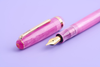 Esterbrook Love Potion Jr fountain pen with pink barrel and gold accents, showcasing its elegant design and smooth writing nib.
