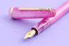 Esterbrook Love Potion Jr fountain pen with pink barrel and gold accents, showcasing a sleek and stylish writing instrument.