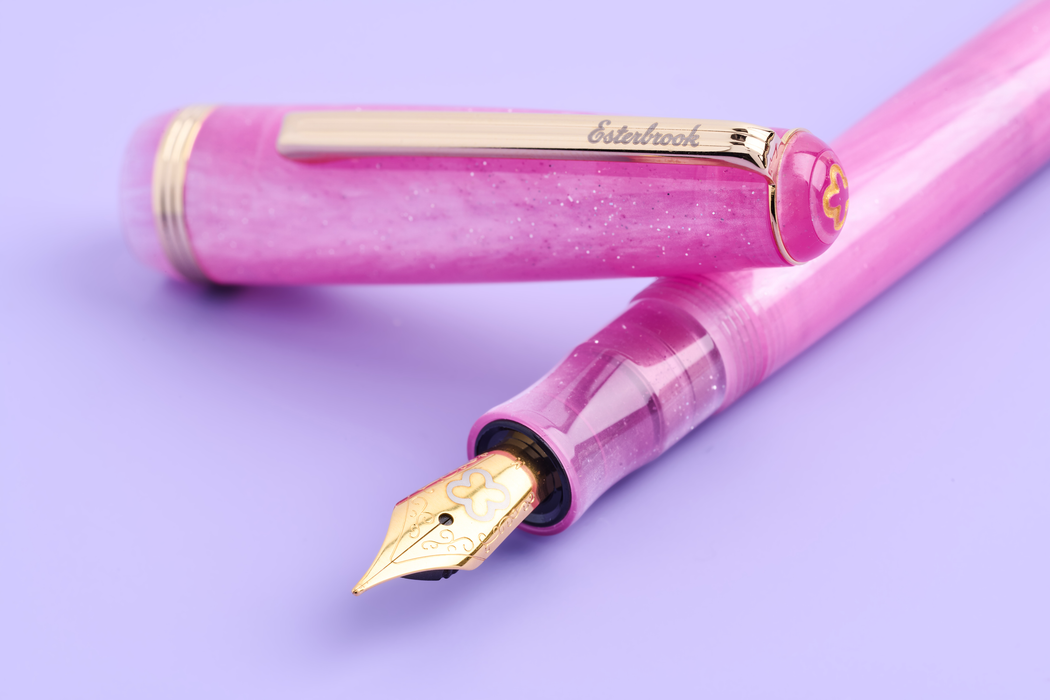 Esterbrook Love Potion Jr fountain pen with pink barrel and gold accents, showcasing a sleek and stylish writing instrument.