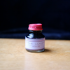Brown fountain pen ink from Papier Plume's Loop Series in a glass bottle with black cap, suitable for fountain pens.