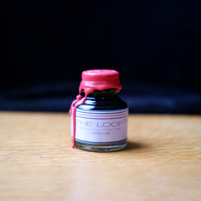 Papier Plume Loop Series fountain pen ink in green, featuring a glass ink bottle with a label and ink inside.
