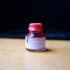 Pink fountain pen ink from Papier Plume's Loop Series, shown in a clear bottle with a colorful label.