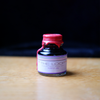 Papier Plume Loop Series fountain pen ink in a purple ink bottle, showcasing the vibrant ink inside and the elegant packaging.