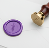 Lavender wax seal with Papier Plume symbol design, used for sealing letters or decorative purposes.
