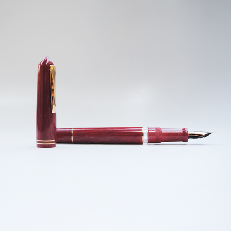 Gioia Luminosa Red fountain pen with a vibrant red illuminated design, showcasing its elegant pen body and nib.