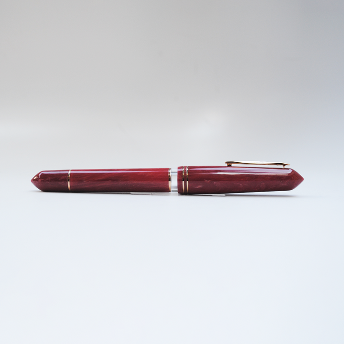 Gioia Luminosa Red fountain pen with a glowing red barrel and gold accents, displayed on a white background.