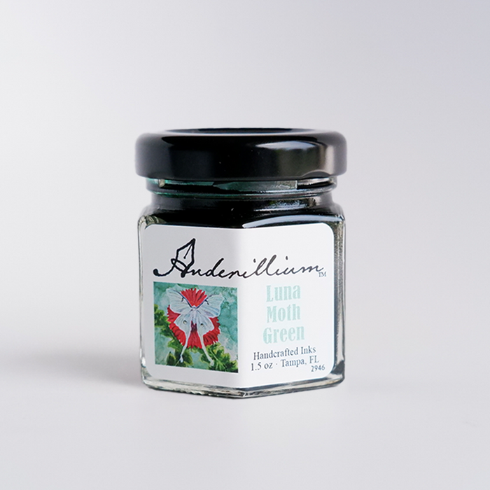 Anderillium Luna Moth Green fountain pen ink in a glass bottle with vibrant green ink visible inside.