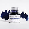 Bottle of Papier Plume Midnight Blue fountain pen ink with a clear glass container and dark blue ink visible inside.